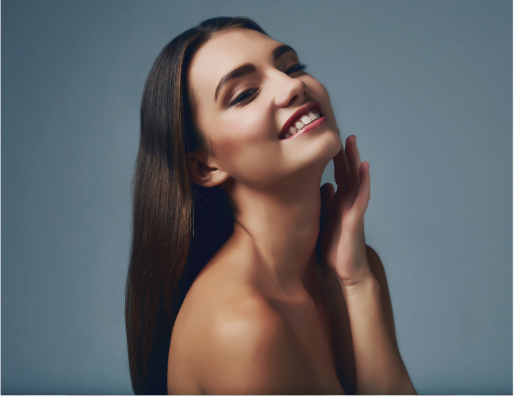 female model holding side of face on blue background