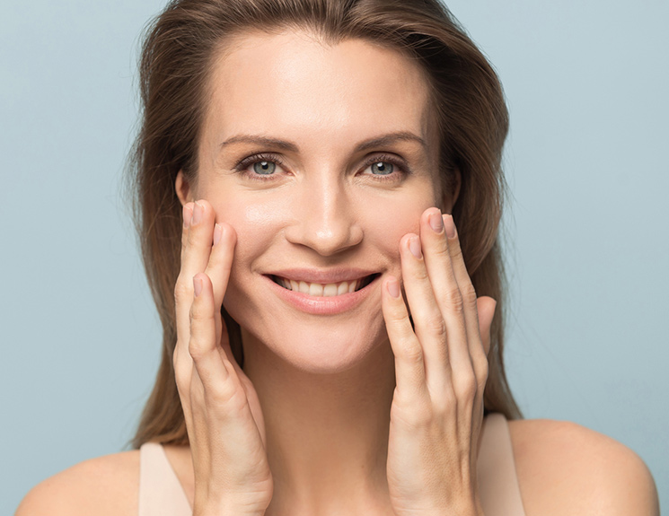 older model holding the sides of her face